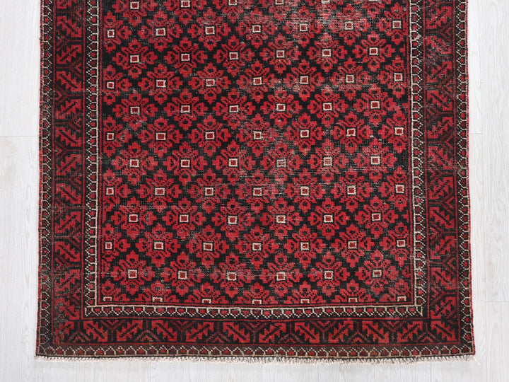 a red and black rug on a white floor