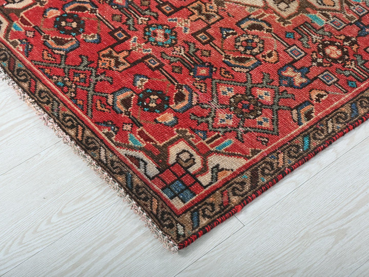 a red rug on a white wooden floor