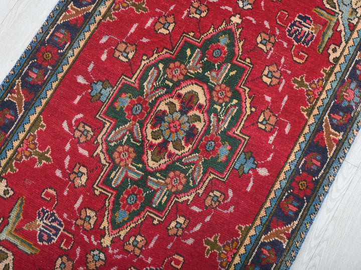 a red rug on a white wooden floor
