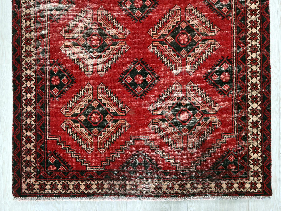 a red rug with a diamond pattern on it