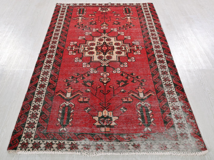 a red rug with a black border on a white floor