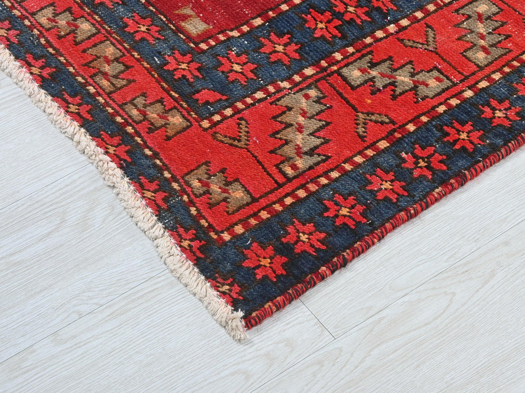 a red and blue rug on a white floor