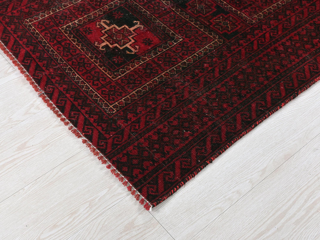 a red and black rug on a white floor