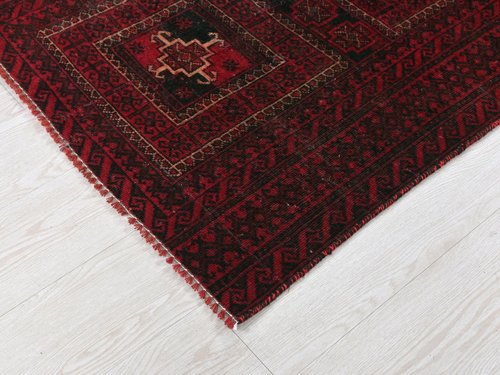 a red and black rug on a white floor