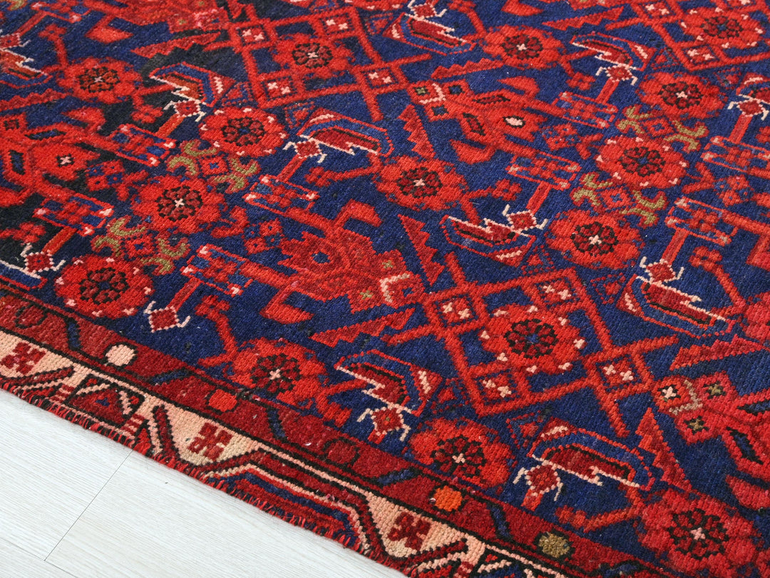 a red and blue rug on a white floor