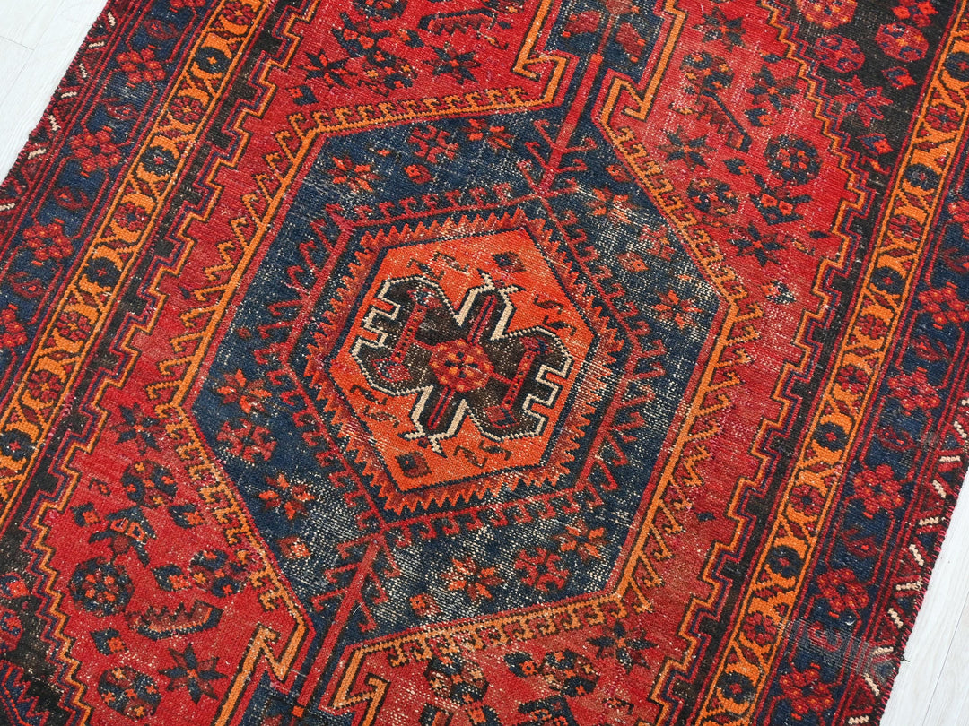 a red, blue, and orange rug with a design on it