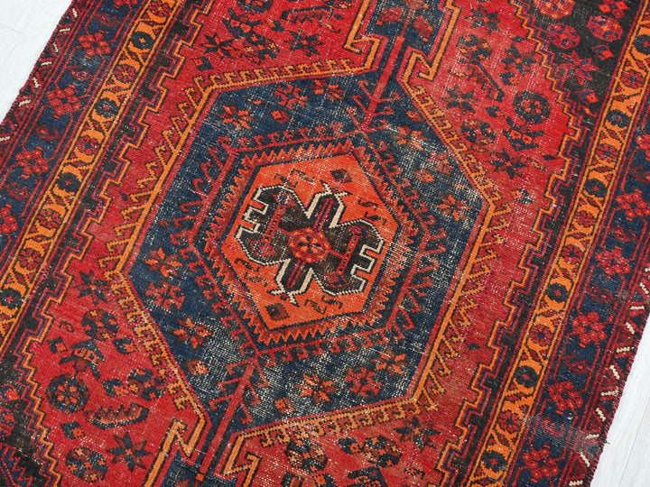 a red, blue, and orange rug with a design on it