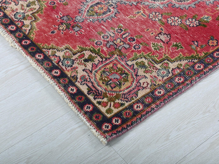 a red oriental rug on a white wooden floor