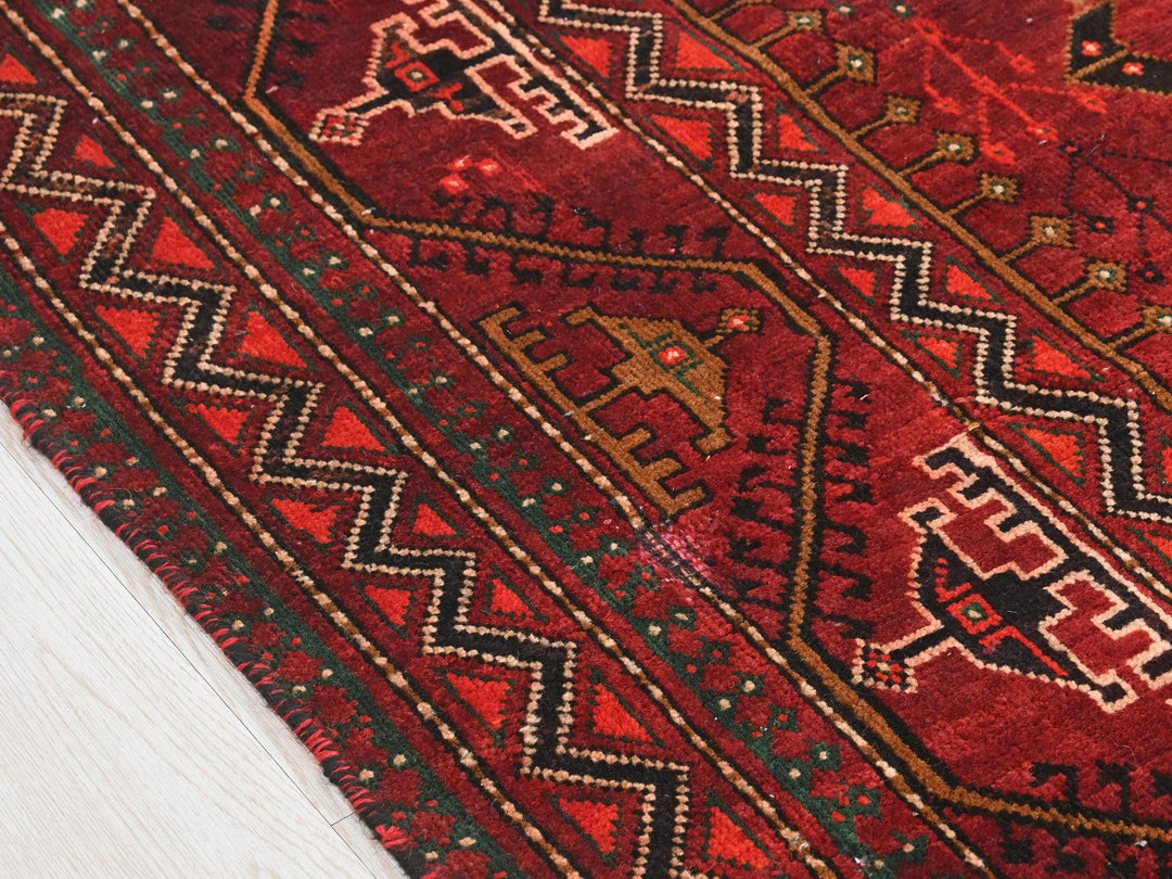 a close up of a red rug on the floor