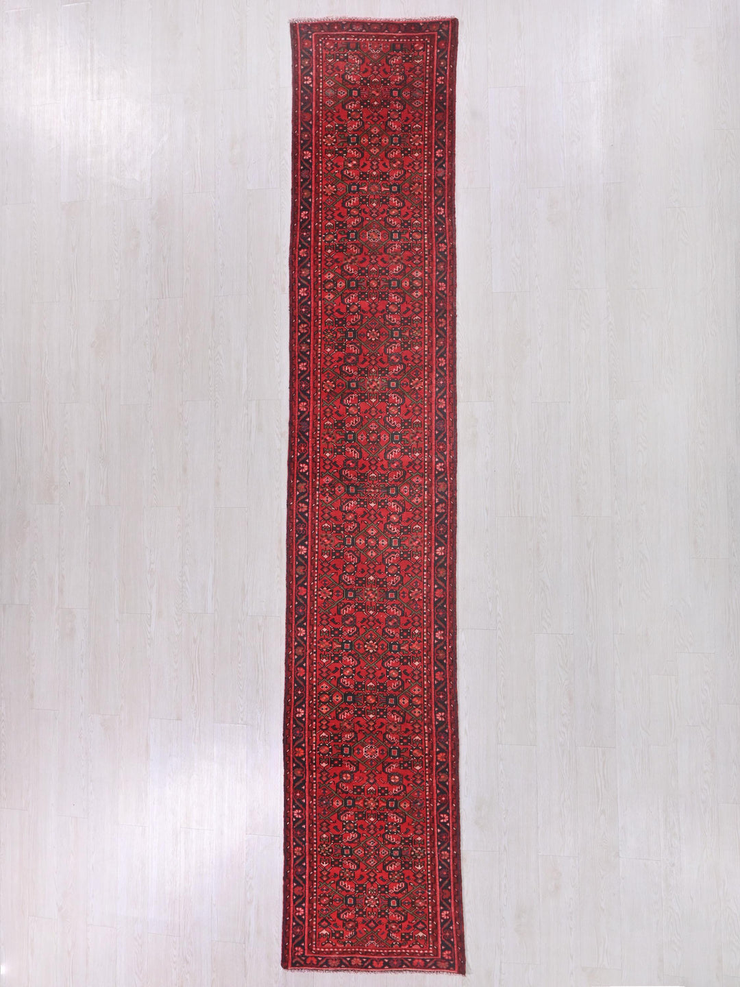 a red and black rug on a white floor