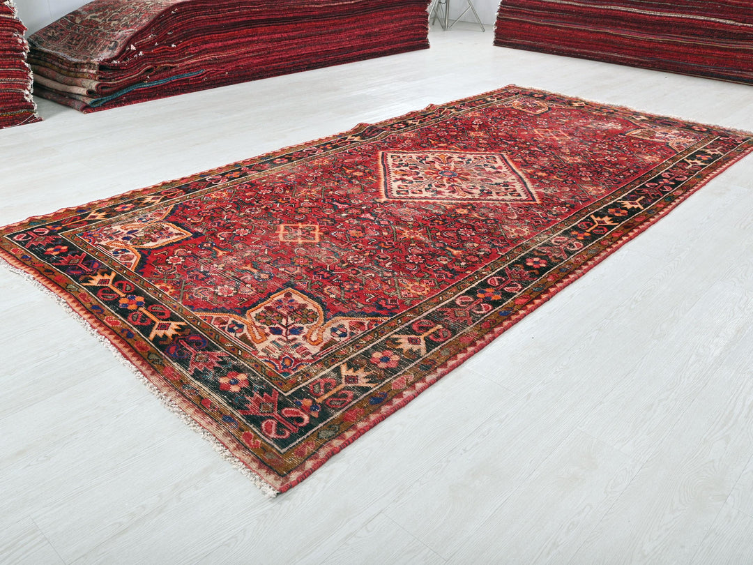 a pile of red rugs sitting on top of a white floor
