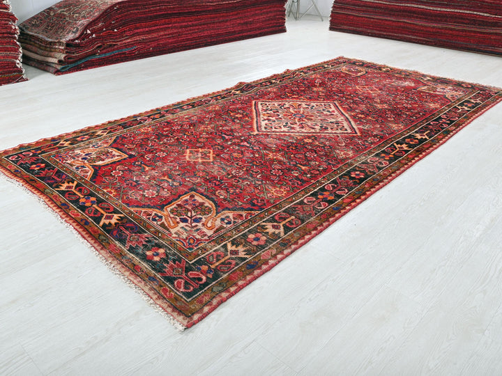 a pile of red rugs sitting on top of a white floor