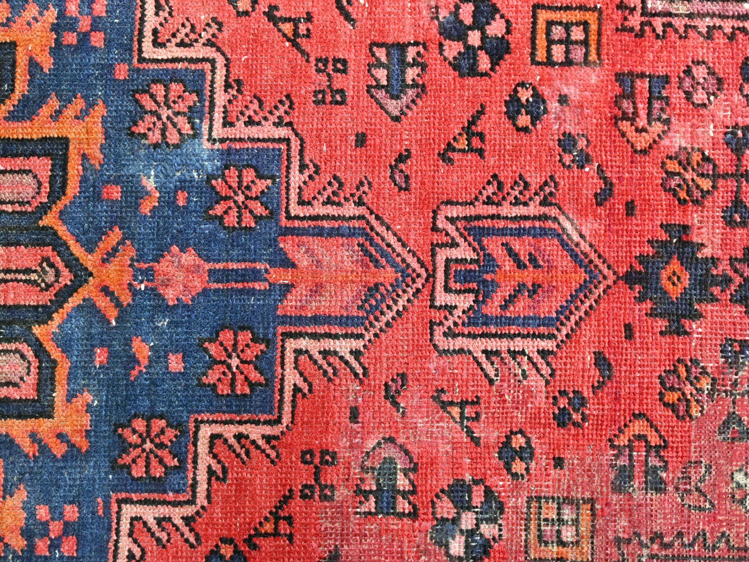 a red rug with a blue design on it