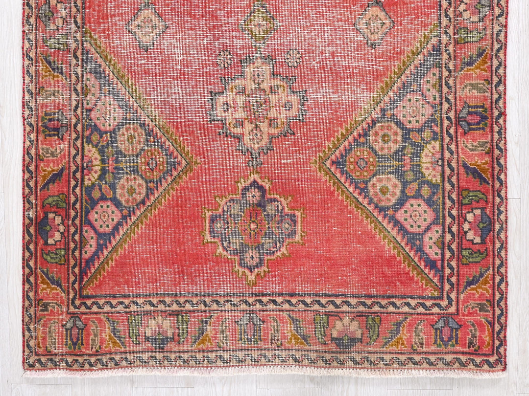 a red, blue, and green rug with a design on it