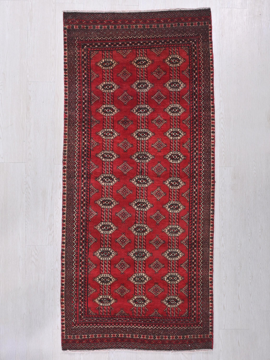 a red rug with a diamond pattern on it