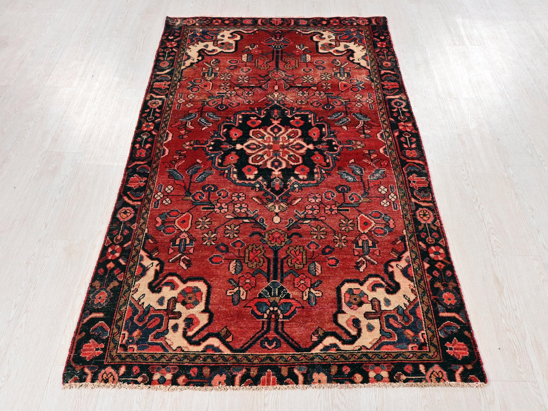 a red oriental rug on a white wooden floor
