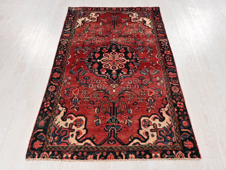 a red oriental rug on a white wooden floor