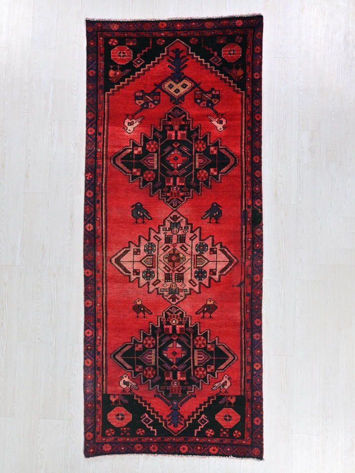 a red and black oriental rug on a white floor