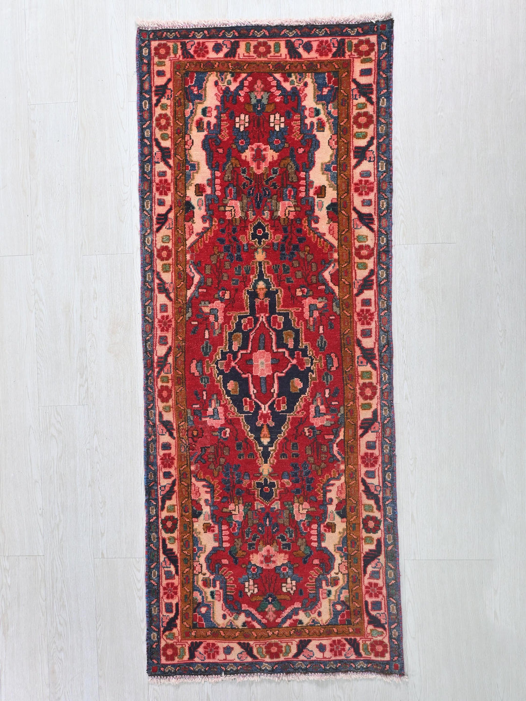 a red and blue rug hanging on a wall