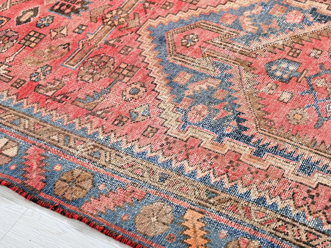 a red rug with a blue and pink design on it