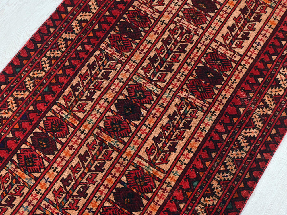 a red and black rug on a white floor