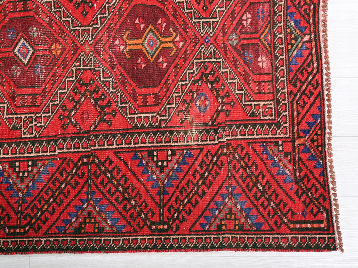 a close up of a red rug on a white surface