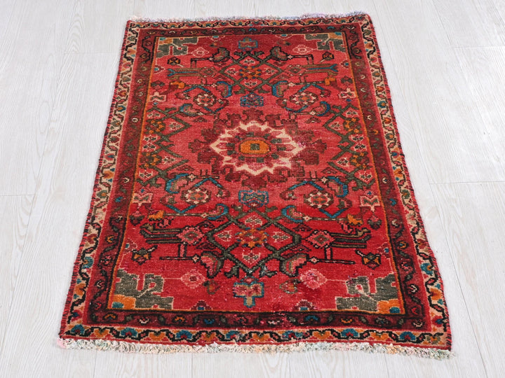 a red oriental rug on a white floor