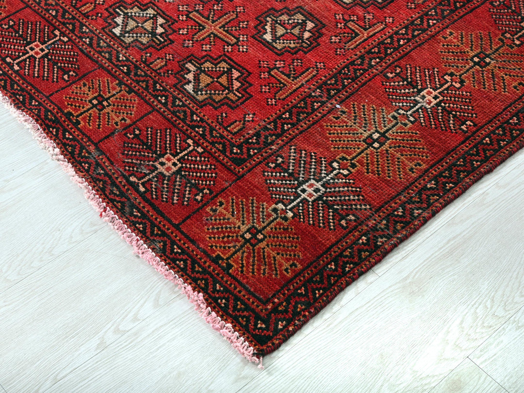 a red rug on a white wooden floor