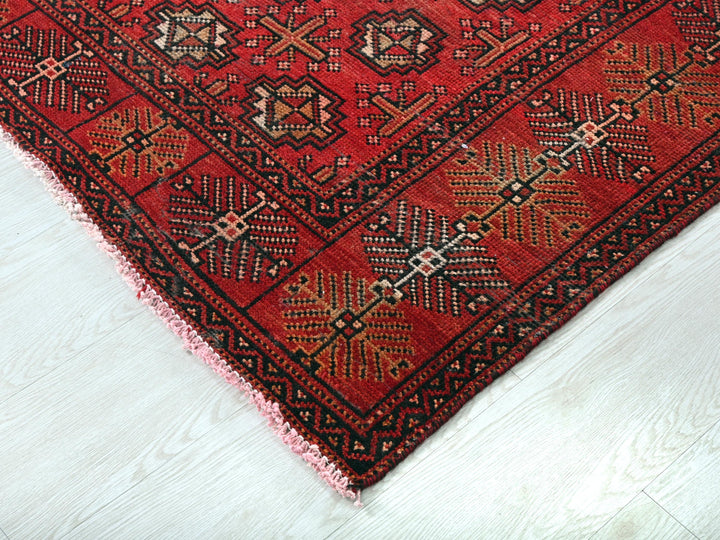 a red rug on a white wooden floor