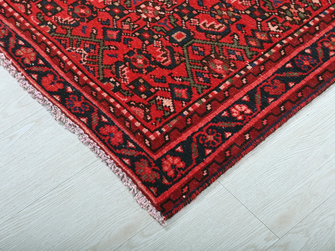 a close up of a red rug on a white floor