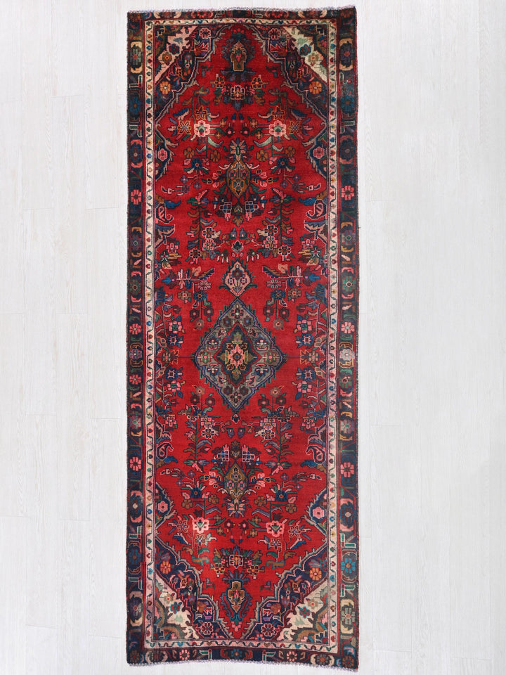 a red rug hanging on a white wall