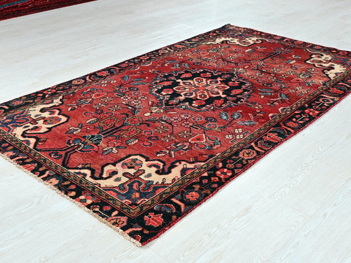 a red oriental rug on a white floor