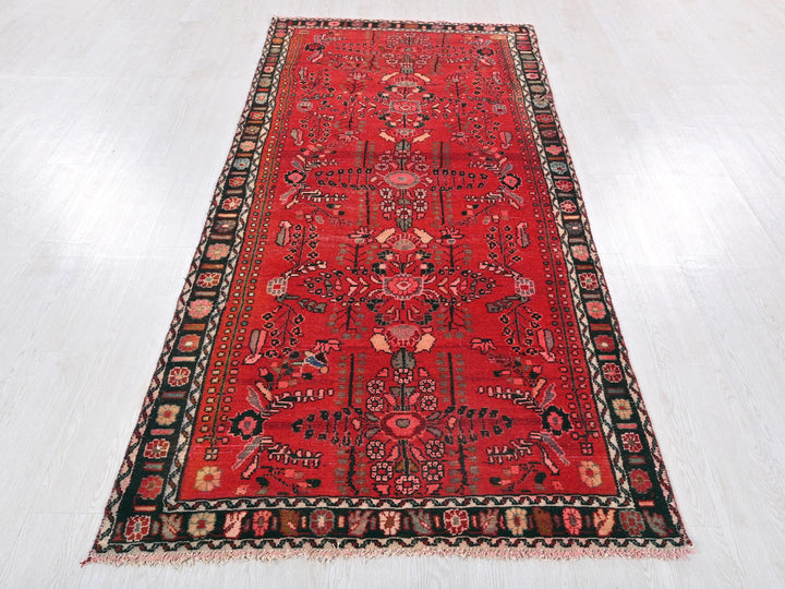 a red rug with a black border on a white floor