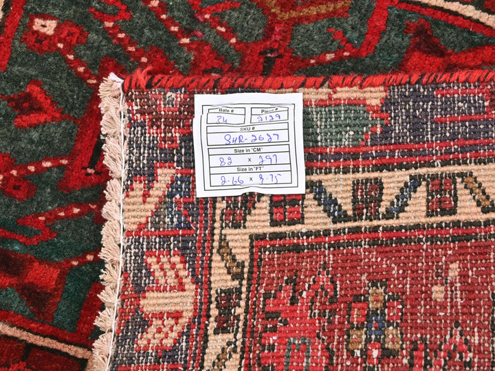 a pile of red and green rugs with a price tag