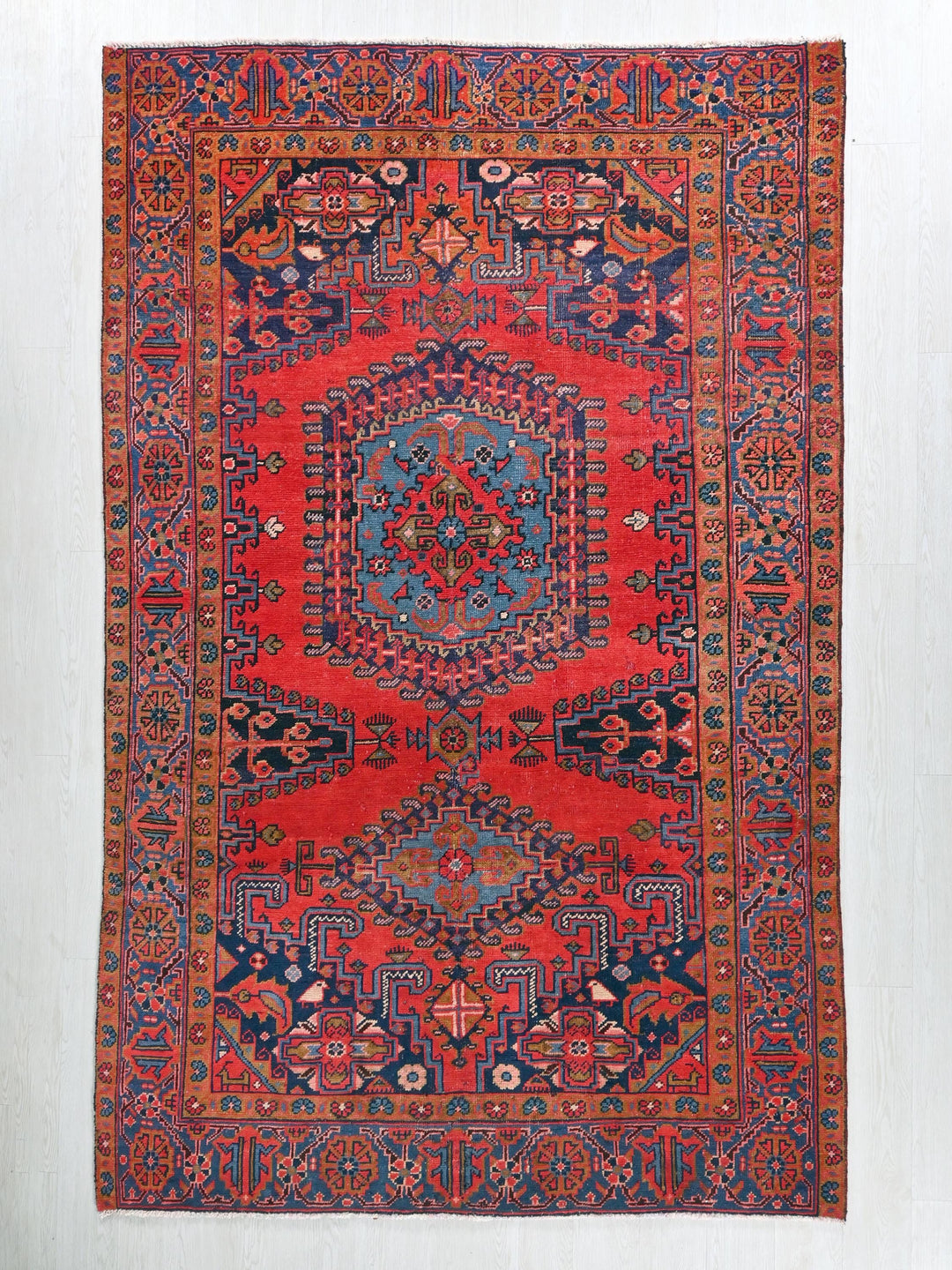 a red rug with a blue and red design on it