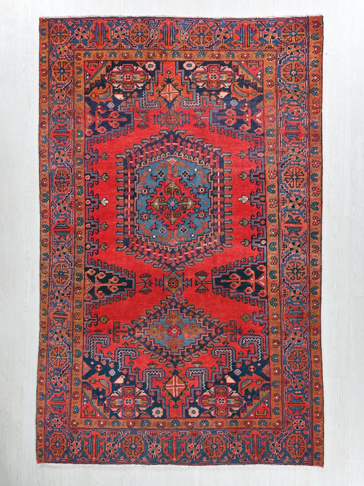 a red rug with a blue and red design on it