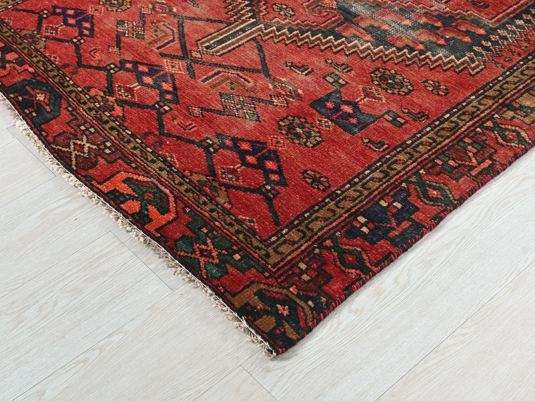 a red oriental rug on a white wooden floor