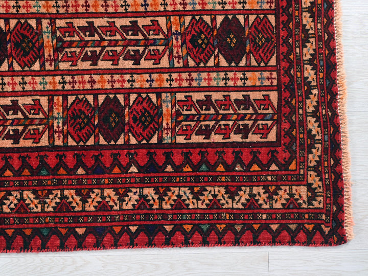 a red and black rug on a white floor