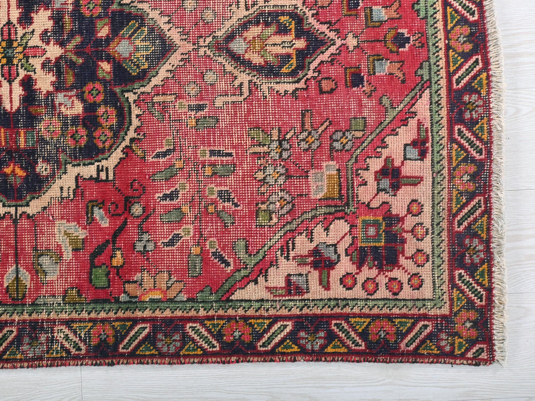 a red rug with a floral design on it
