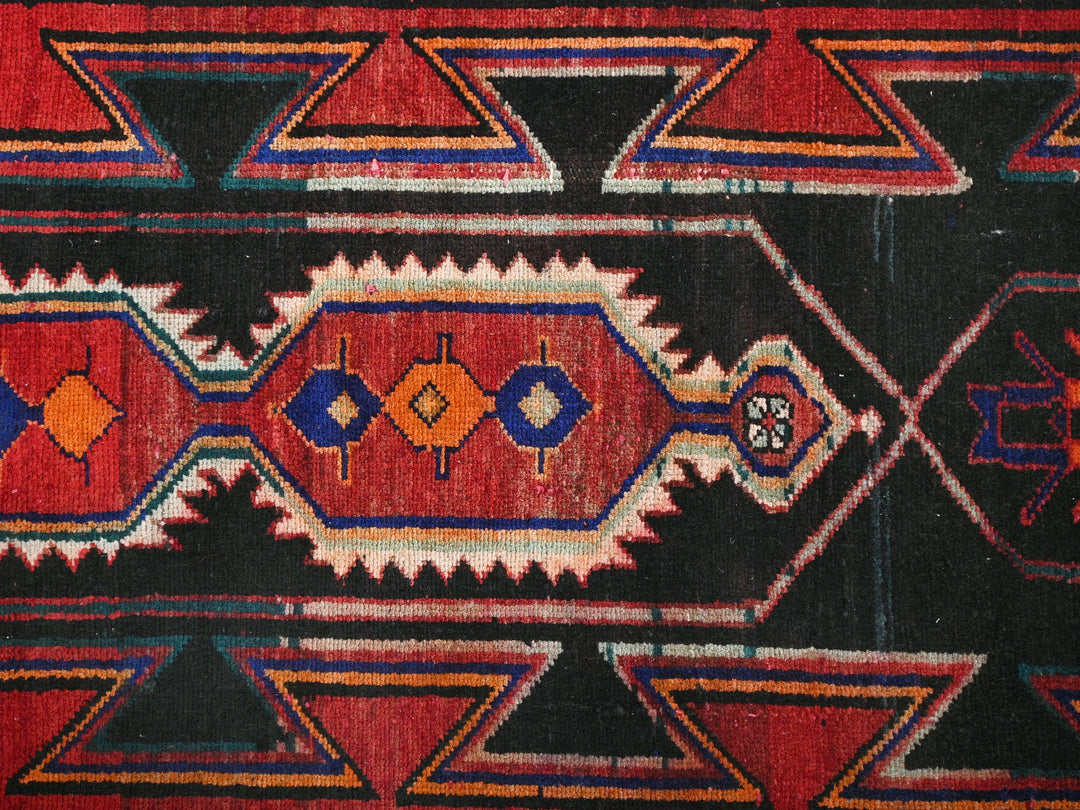 a red and black area rug with a design on it