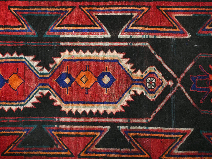 a red and black area rug with a design on it