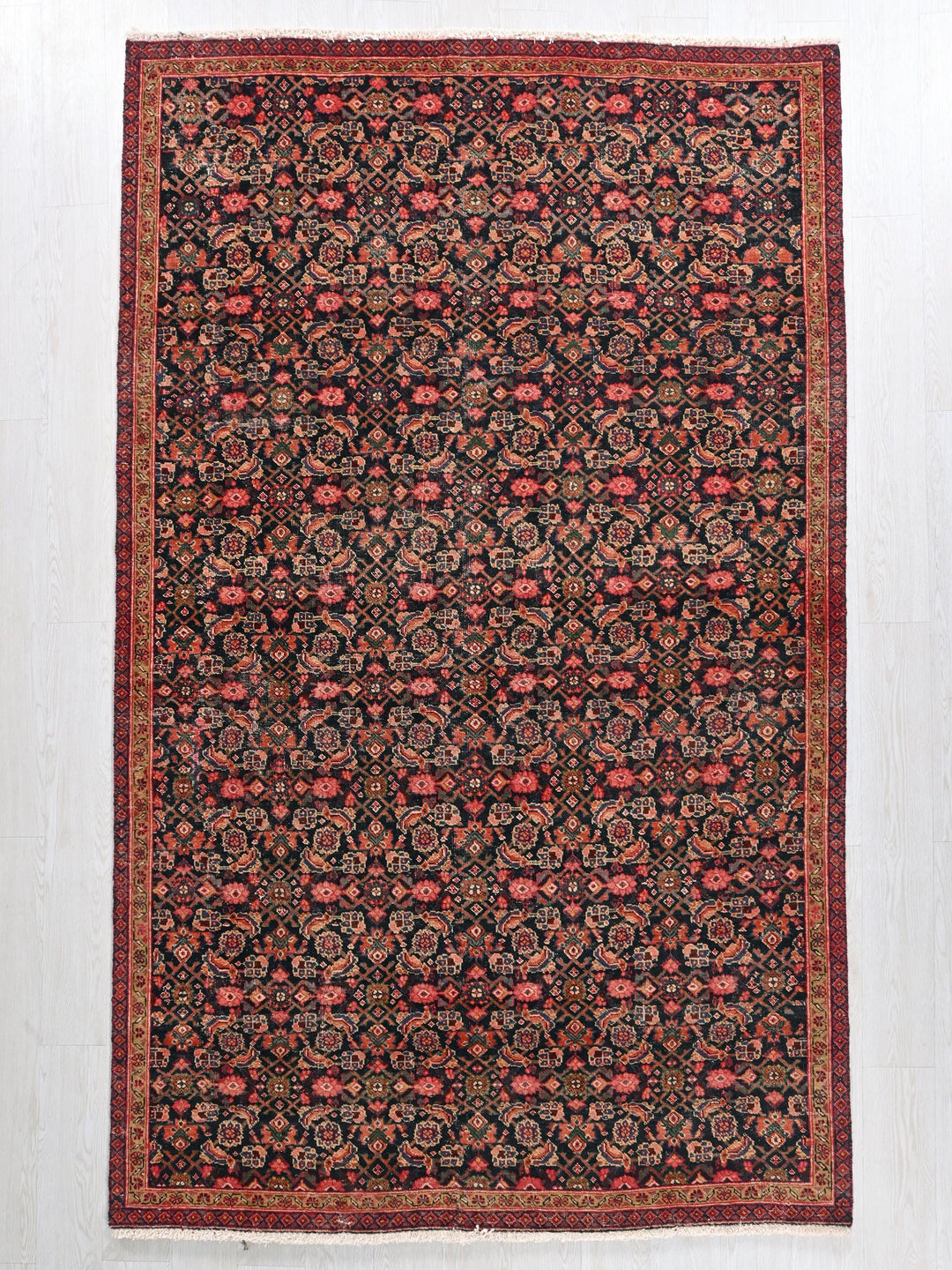 a black and red rug on a white floor