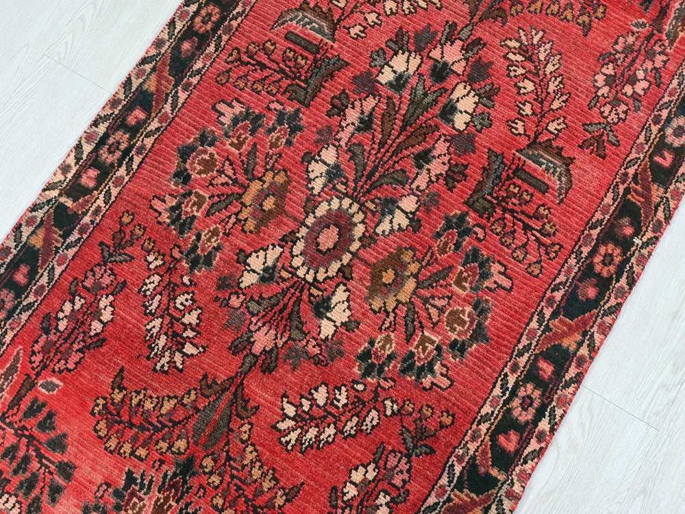 a red oriental rug on a white wooden floor