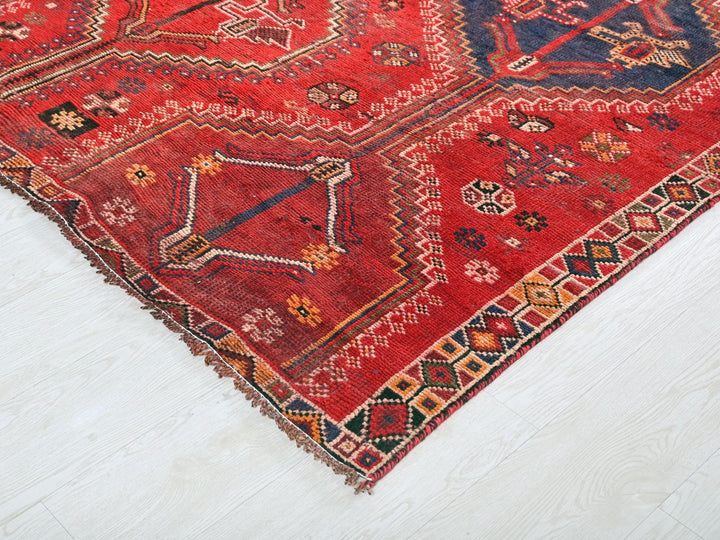 a red oriental rug on a white floor