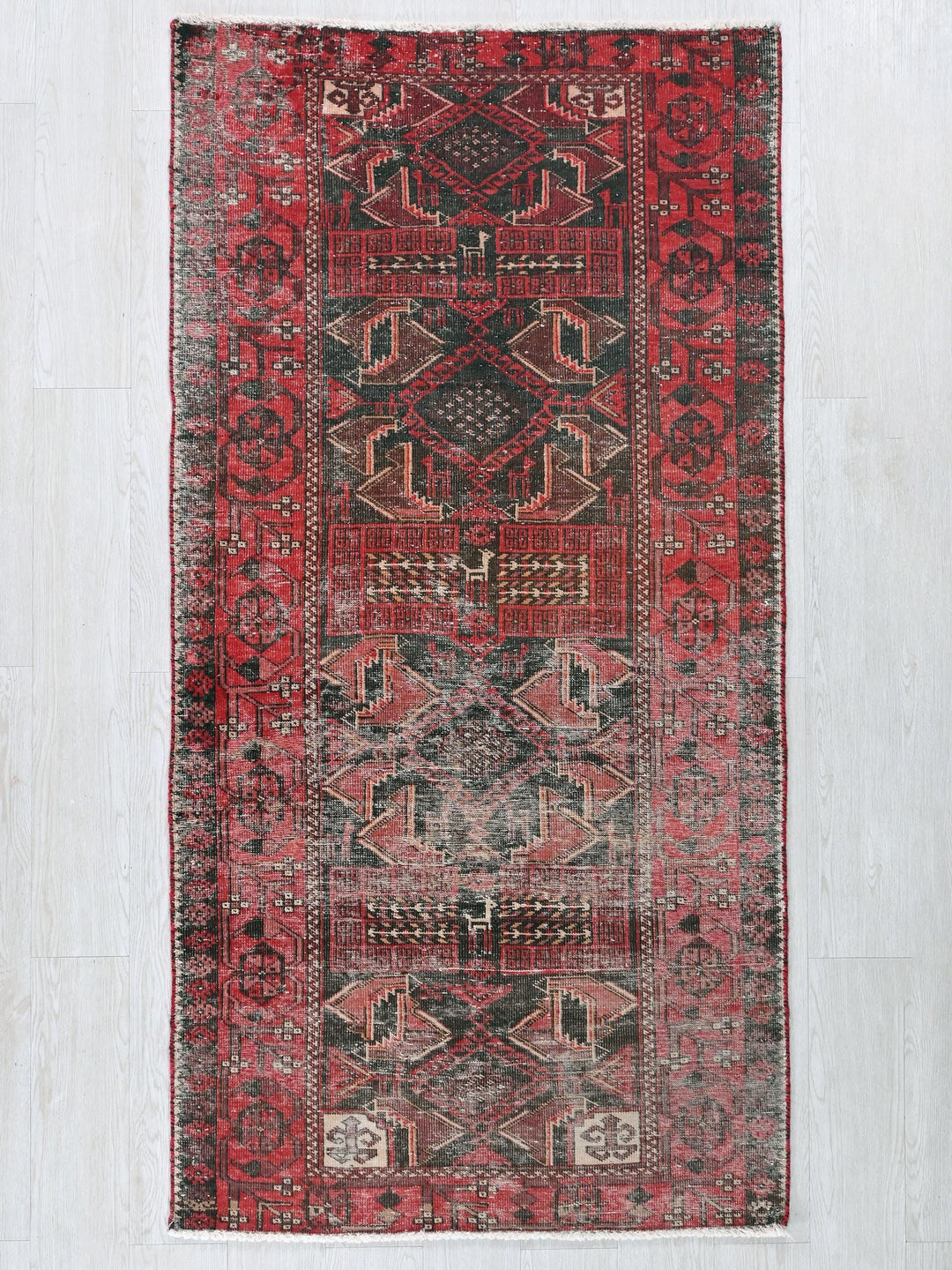 a red and black rug on a white floor
