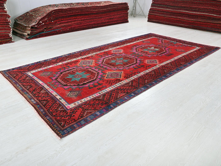 a pile of red rugs sitting on top of a white floor