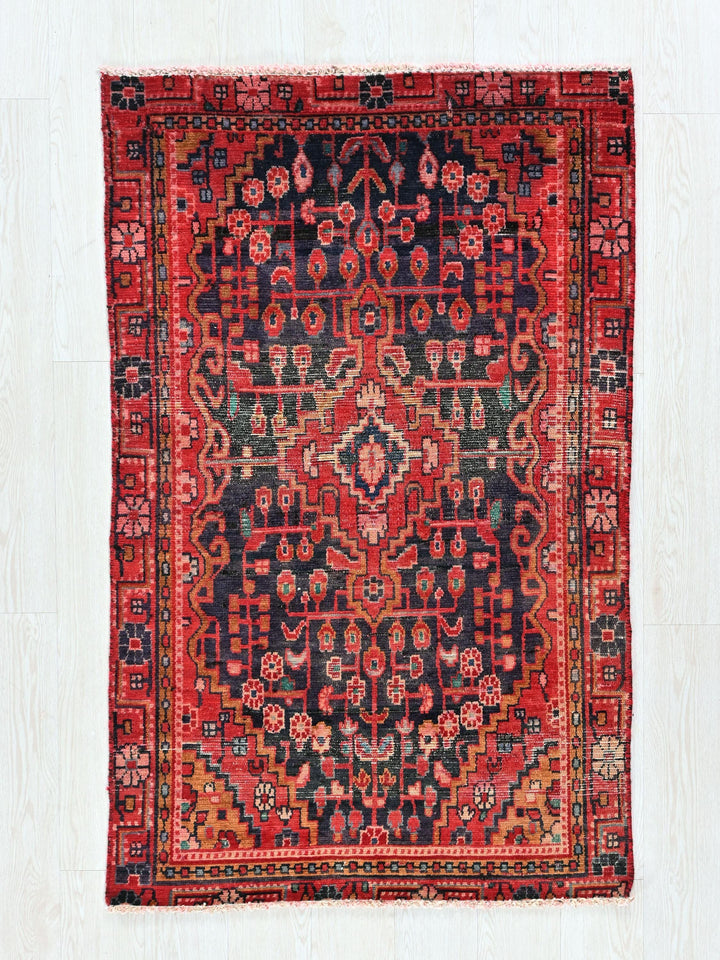 a red and black rug on a white floor