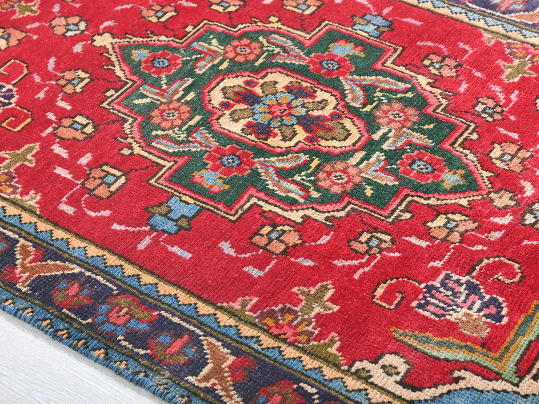 a red oriental rug on a white wooden floor