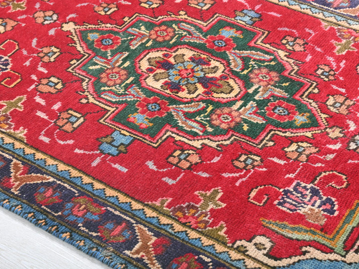 a red oriental rug on a white wooden floor