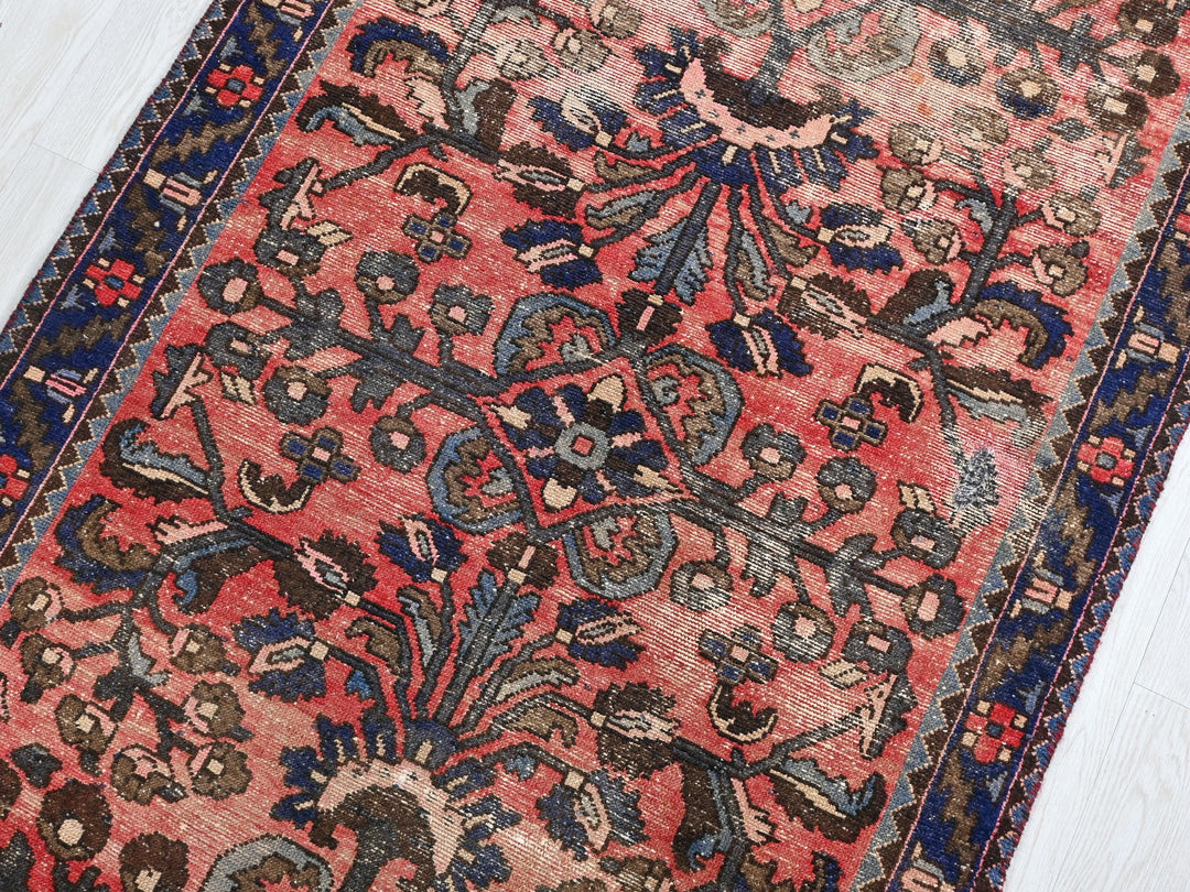 a red rug with a blue border on a white floor